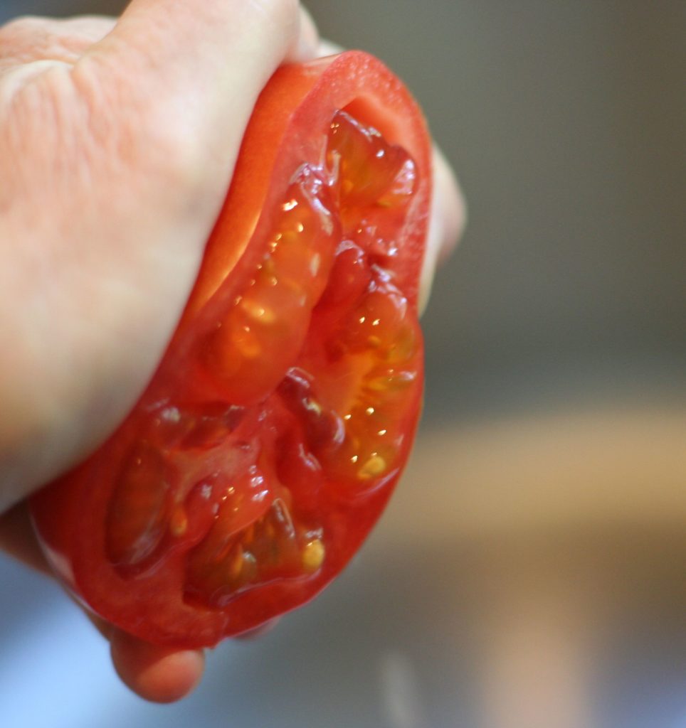 Squeezing Pulp and Seeds from Tomato
