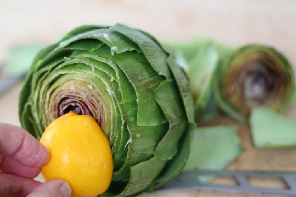 Rubbing the Top of a Trimmed Artichoke with Lemon